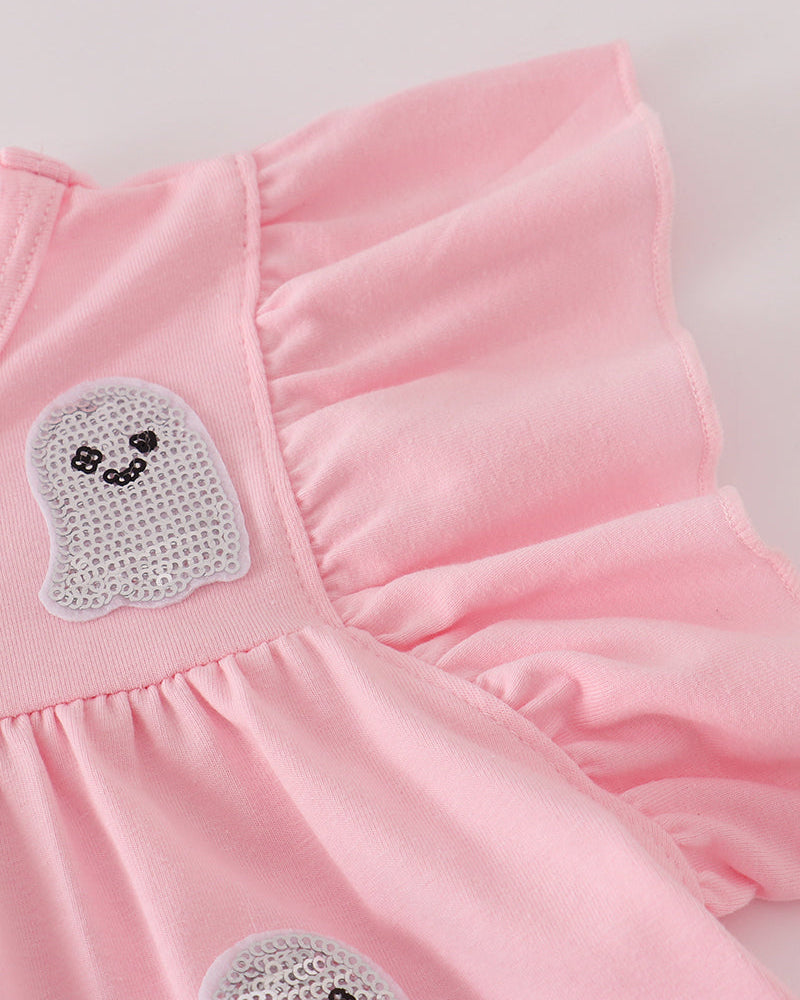 Close-up of a light pink ruffled garment with two ghost-shaped appliques featuring embroidered black facial features on a white mesh backing.
