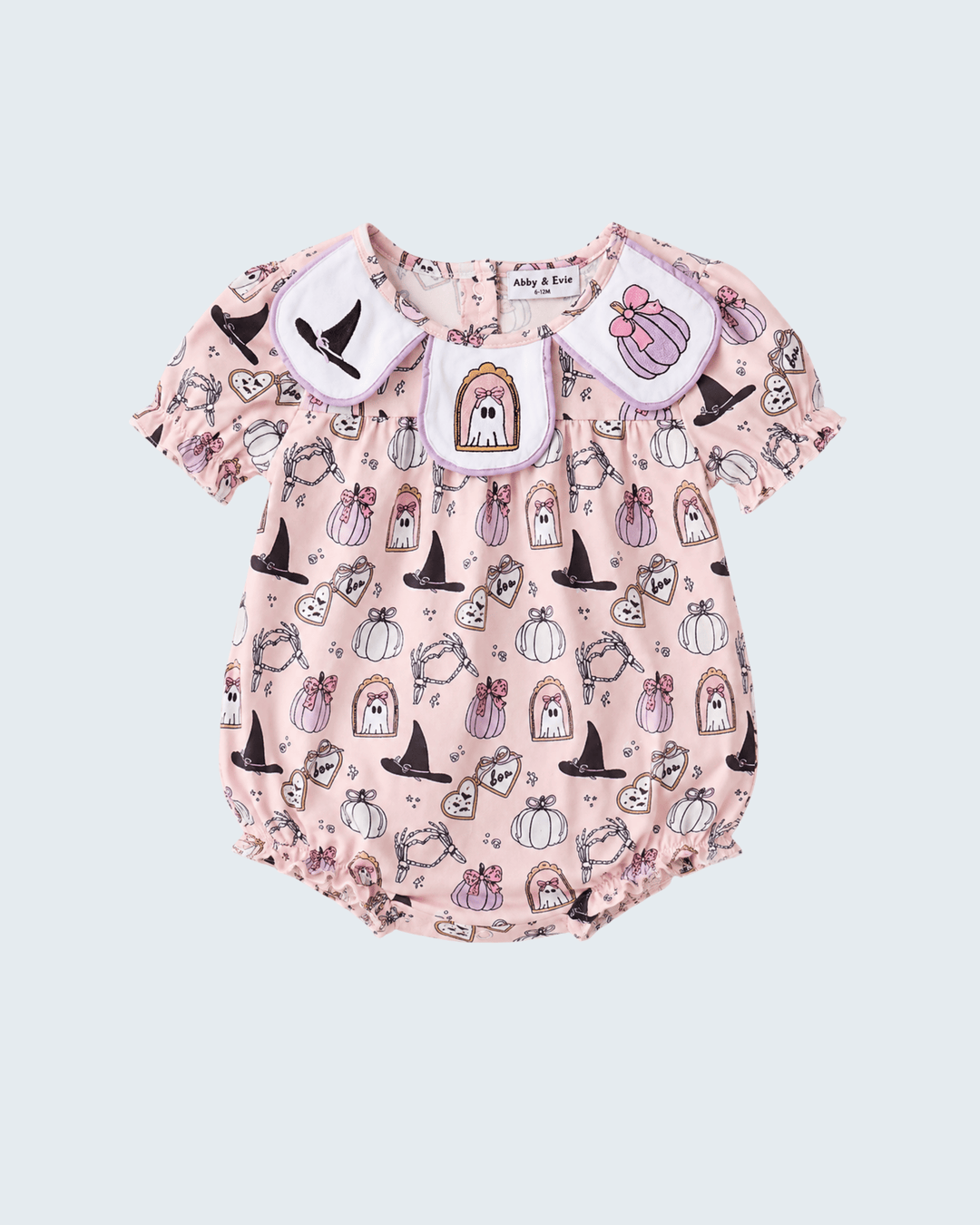 A baby romper in light pink with a Halloween-themed print of pumpkins, witch hats, ghosts, and a haunted house, featuring a white collar with embroidered details.