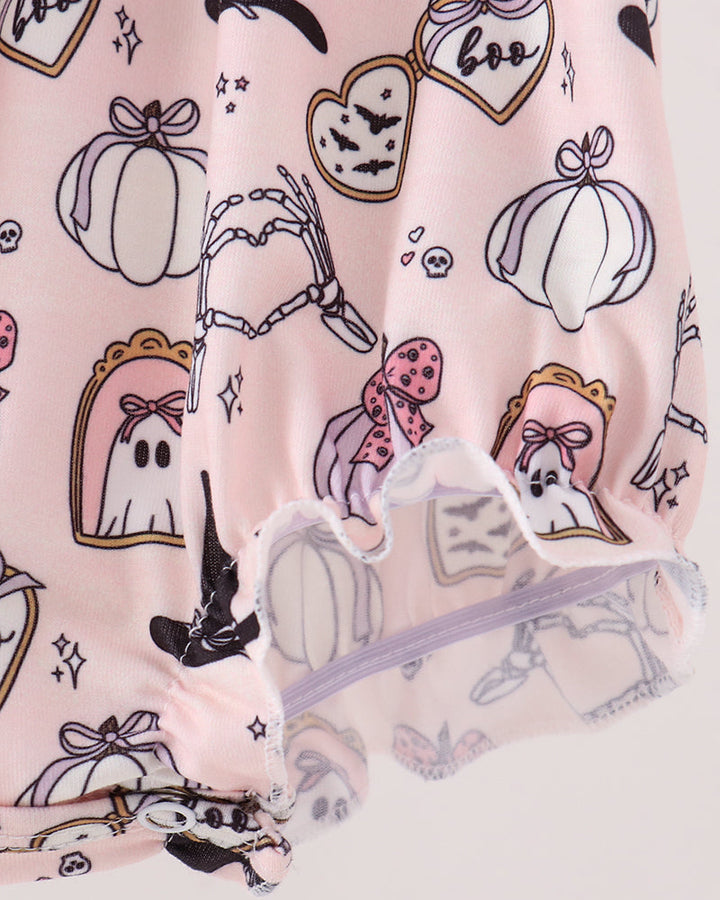A close-up of a light pink fabric item, likely a skirt or dress, featuring a Halloween-themed print with ghosts, pumpkins, bats, and a witch hat. The fabric has a ruffled hem with a sheer mesh overlay.