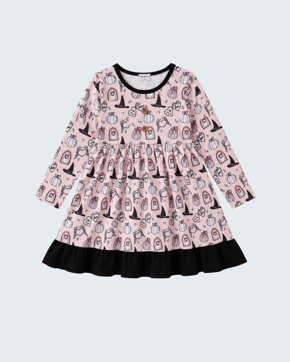 A long-sleeve children's dress with a pink background and an all-over black and white pumpkin and witch illustration pattern, featuring a black ruffled hem and black trim.