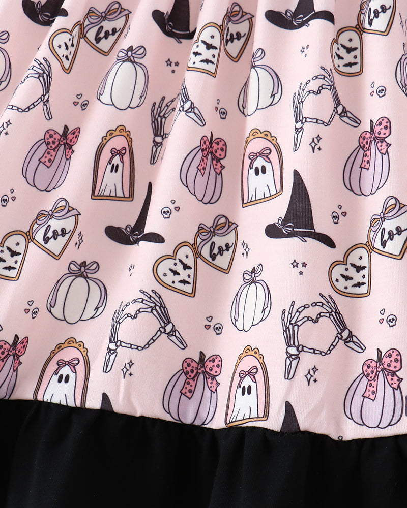 A close-up of a pink Halloween-themed dress  featuring a printed pattern of ghosts, pumpkins, witch hats, skeletons, and tags, finished with a black ruffled hem.