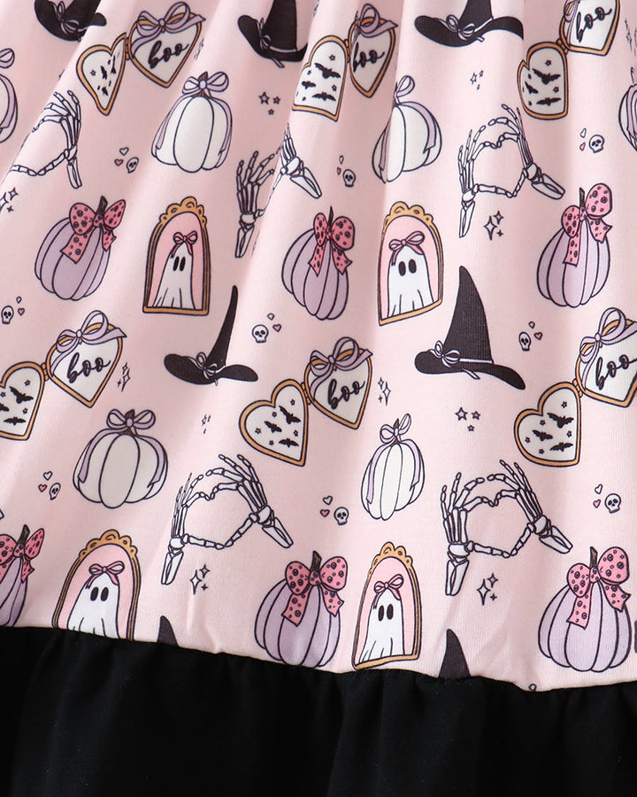 A close-up of a pink Halloween-themed dress  featuring a printed pattern of ghosts, pumpkins, witch hats, skeletons, and tags, finished with a black ruffled hem.