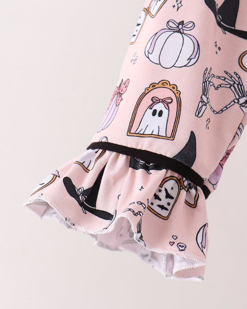 A close-up of a light pink ruffled sleeve or garment featuring a Halloween print with pumpkins, ghosts, witch hats, bats, and skeletons, finished with a black elastic band.