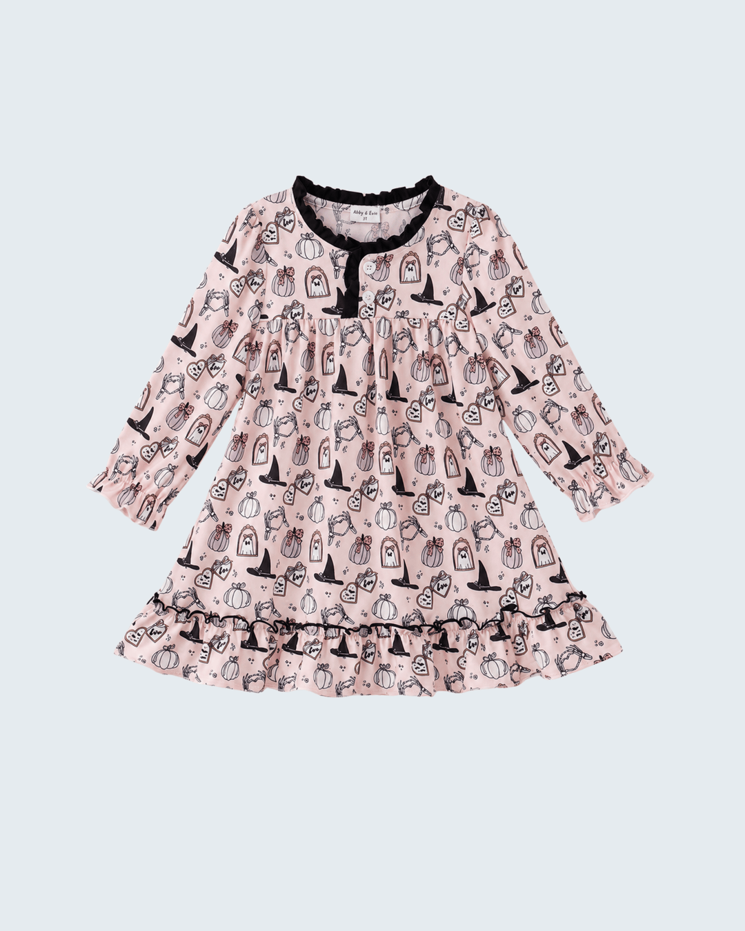 A long-sleeve baby dress in light pink with a black and white pumpkin print, featuring a ruffled hem and neckline with black trim, shown against a light gray background.