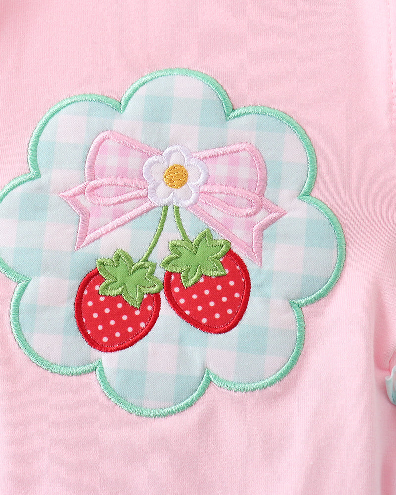 Pink fabric with a floral design featuring strawberries and a bow.