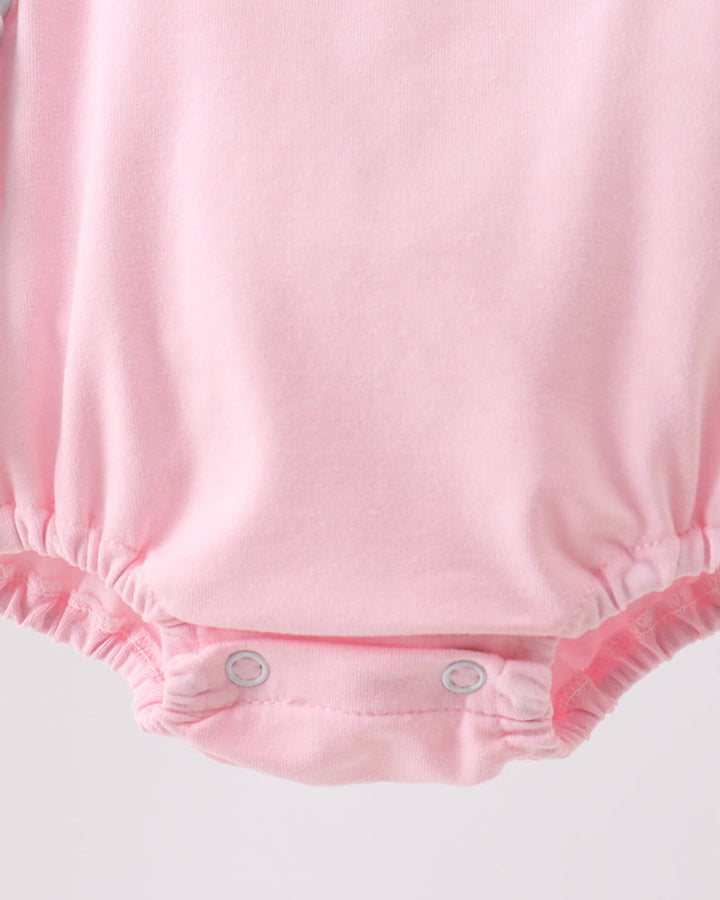 Pink baby romper on a light gray background
