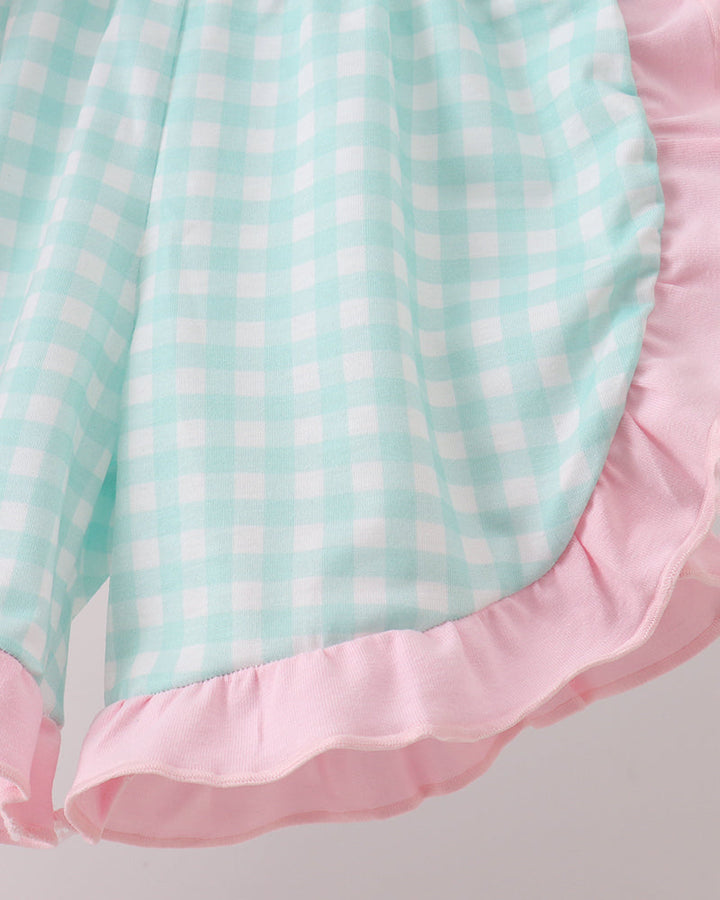 Close-up of a checkered fabric with pink and green pattern on a light gray background