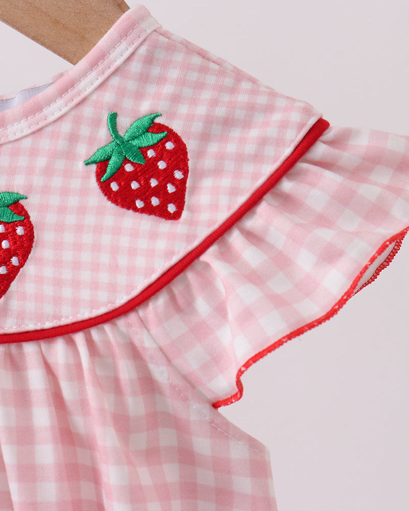 Close up of strawberry embroidery on pink gingham romper