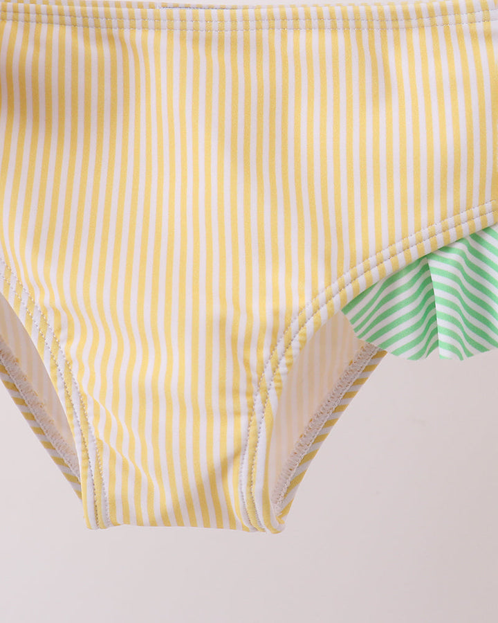 Yellow striped swim bottoms with green lining on a white background