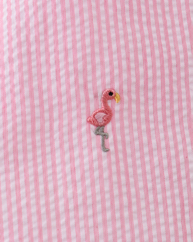 Pink and white striped fabric with a small embroidered flamingo design.