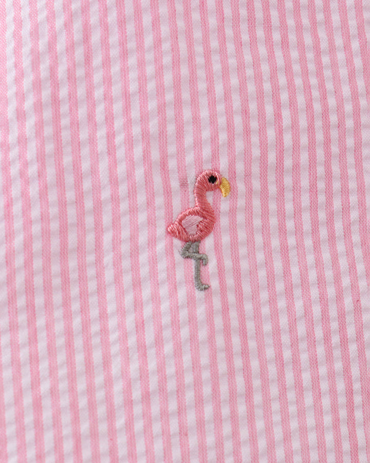 Pink and white striped fabric with a small embroidered flamingo design.