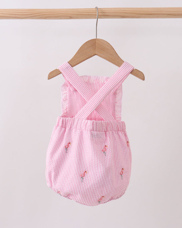 Pink baby romper with floral patterns on a wooden hanger against a white background
