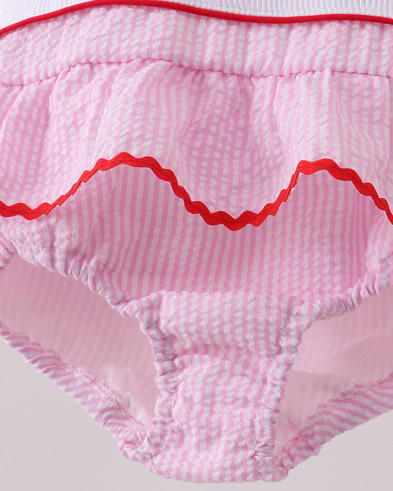 Pink swimsuit with red trim on a light gray background