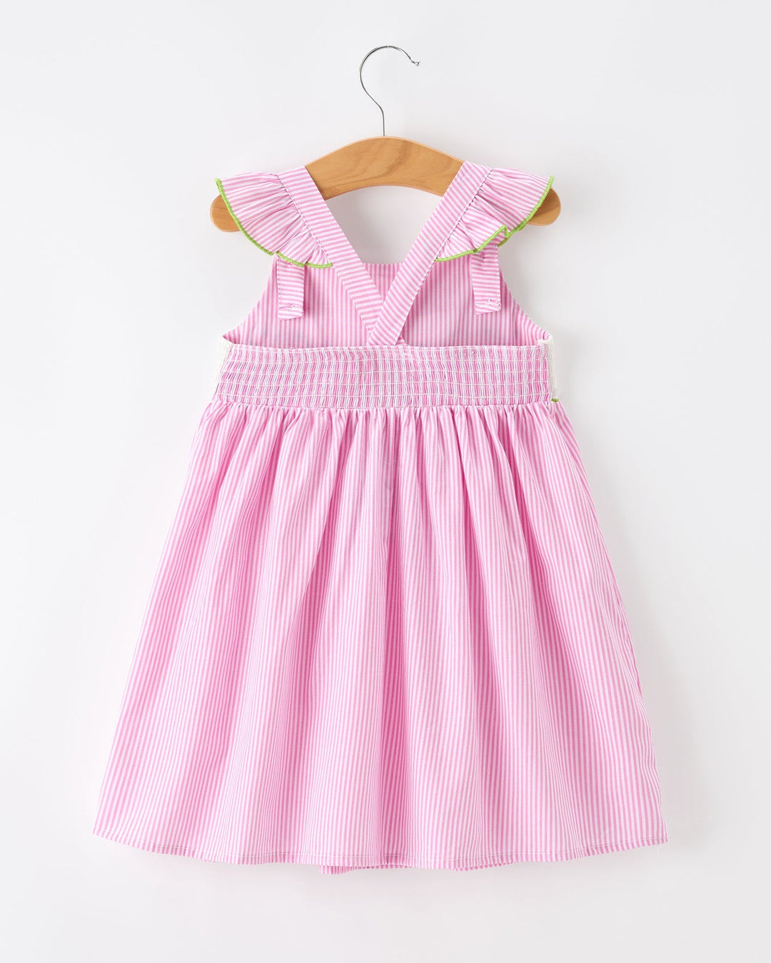 Pink striped dress with ruffled collar on a wooden hanger against a white background