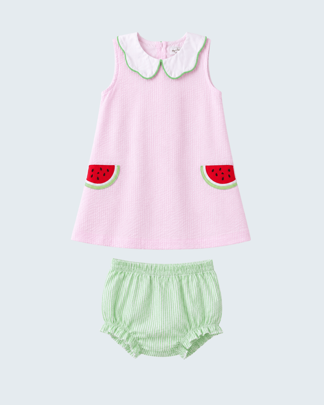 Pink dress with watermelon design and green bloomers on a light gray background