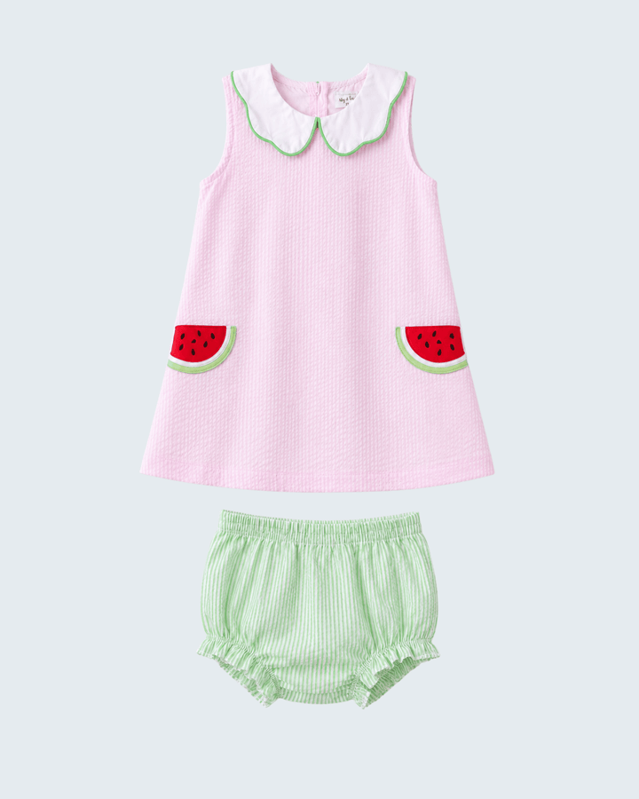 Pink dress with watermelon design and green bloomers on a light gray background