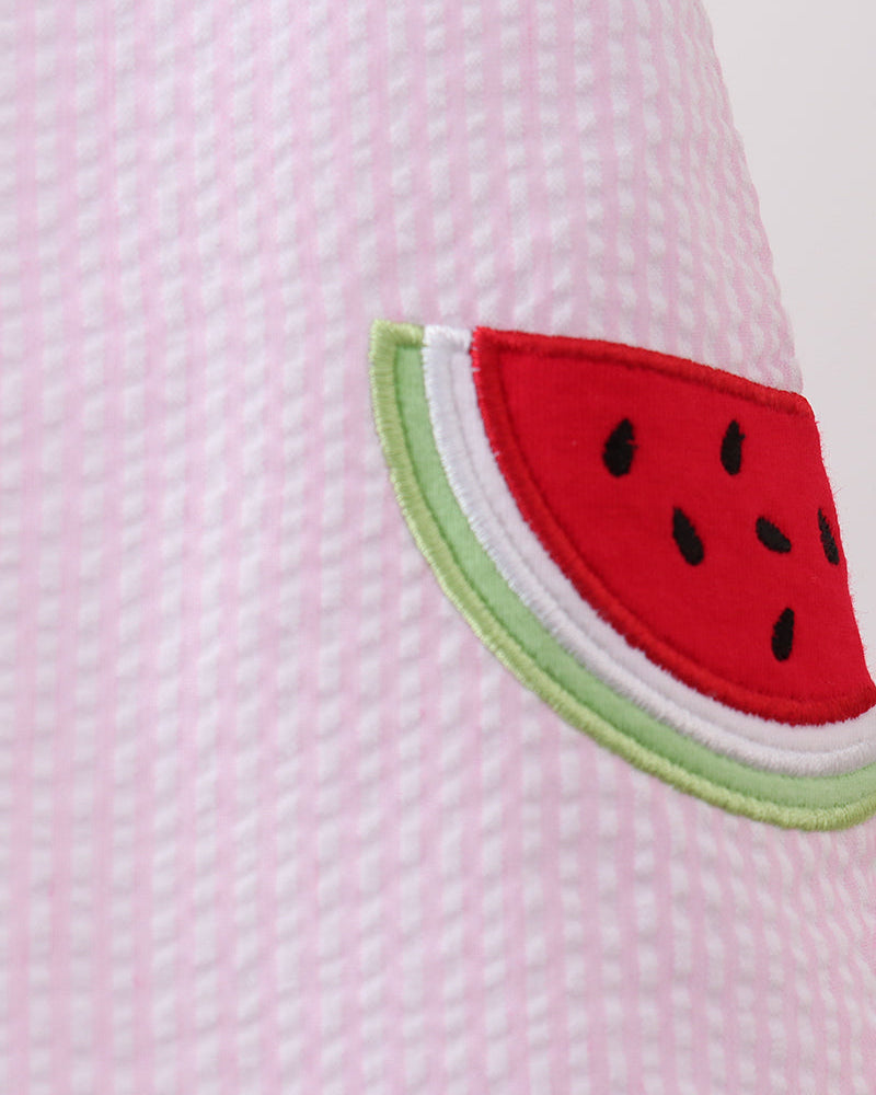 Close-up of a pink textured fabric with a watermelon slice design.