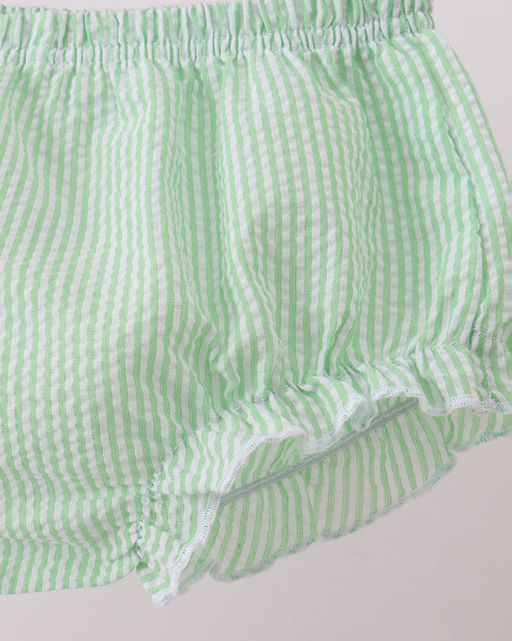 Green and white striped shorts on a light gray background