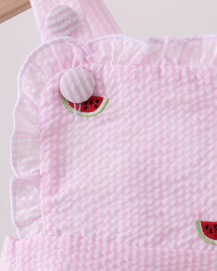 Pink textured romper with watermelon designs on a white background