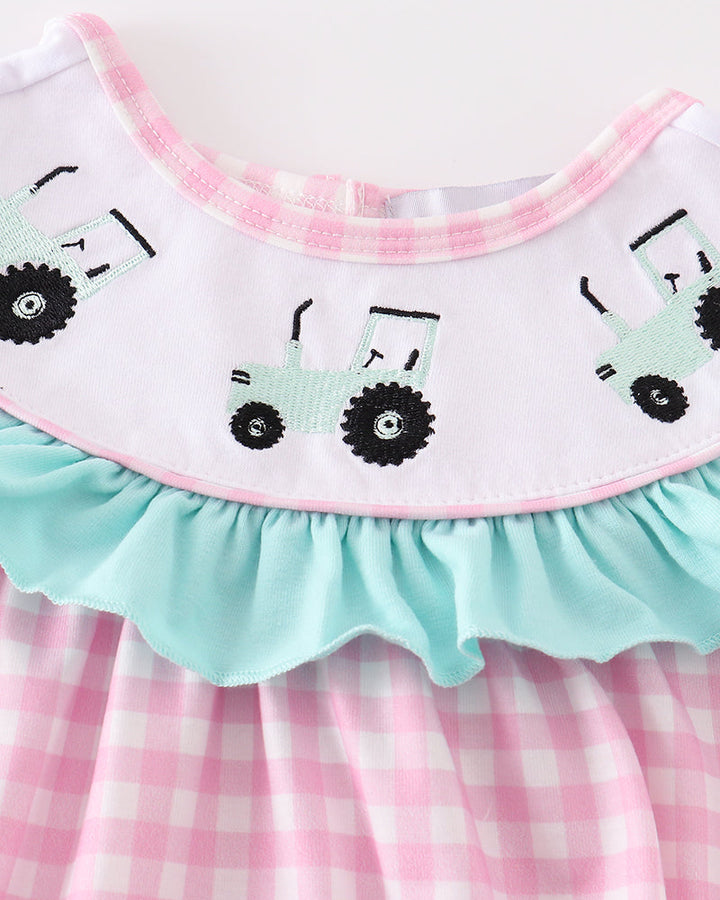 Pink checkered dress with embroidered tractors on a white background