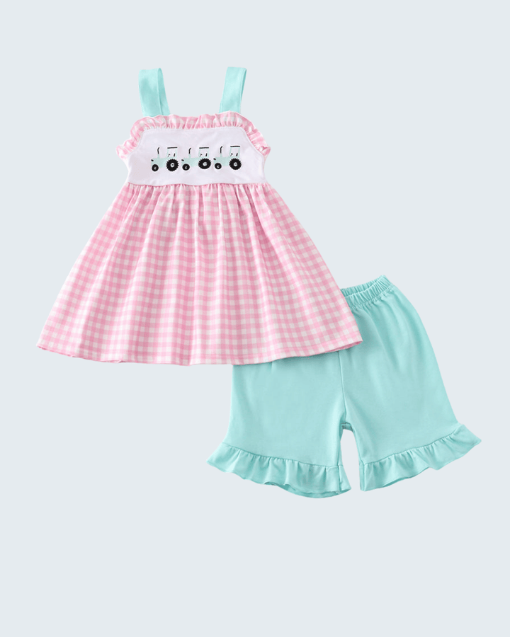 Pink checkered dress with white top and light blue shorts on a light gray background