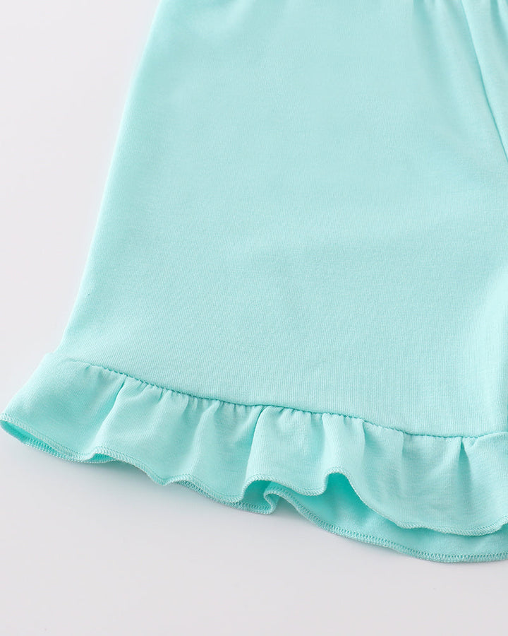 Close-up of a light blue shorts with ruffled hem on a white background