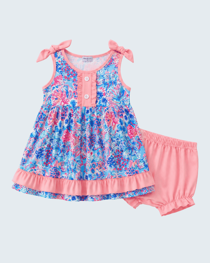 Floral dress with pink accents and matching bloomers on a light gray background