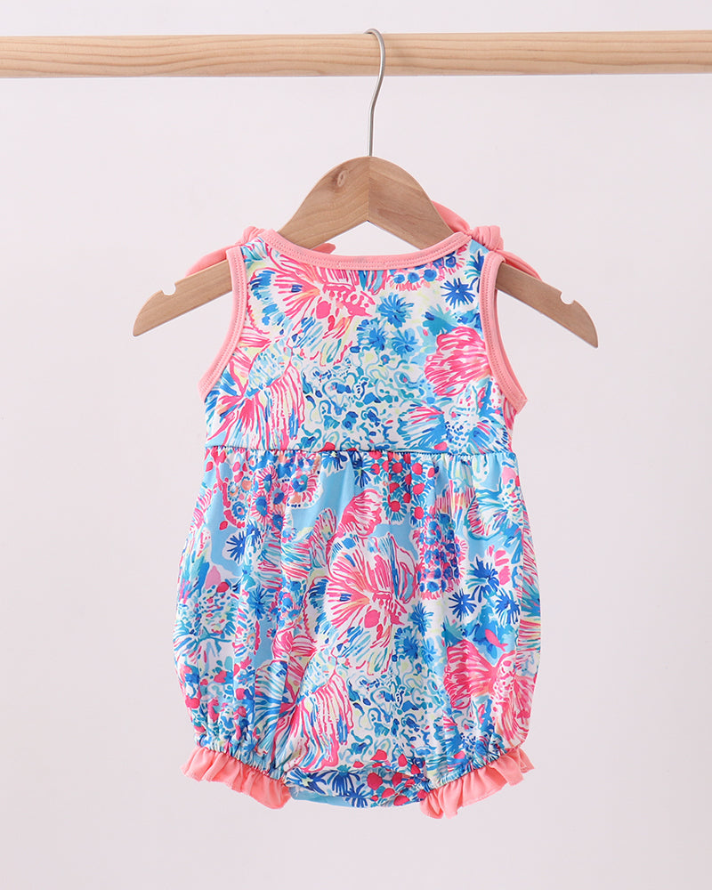 Floral baby romper on a hanger against a white background