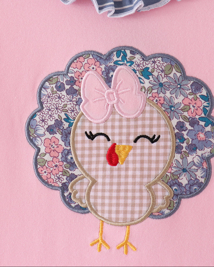 Pink dress with turkey appliqué, floral patch, and ruffle trim