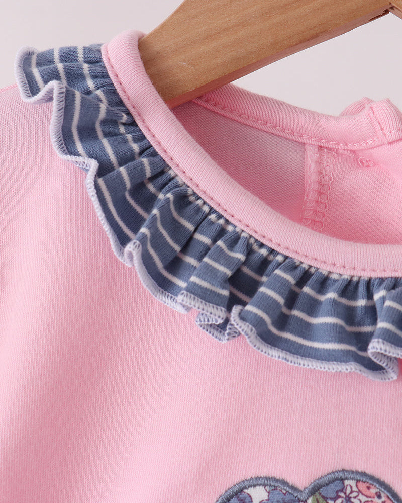 Pink-trimmed neckline and blue striped ruffle detail on long-sleeve top
