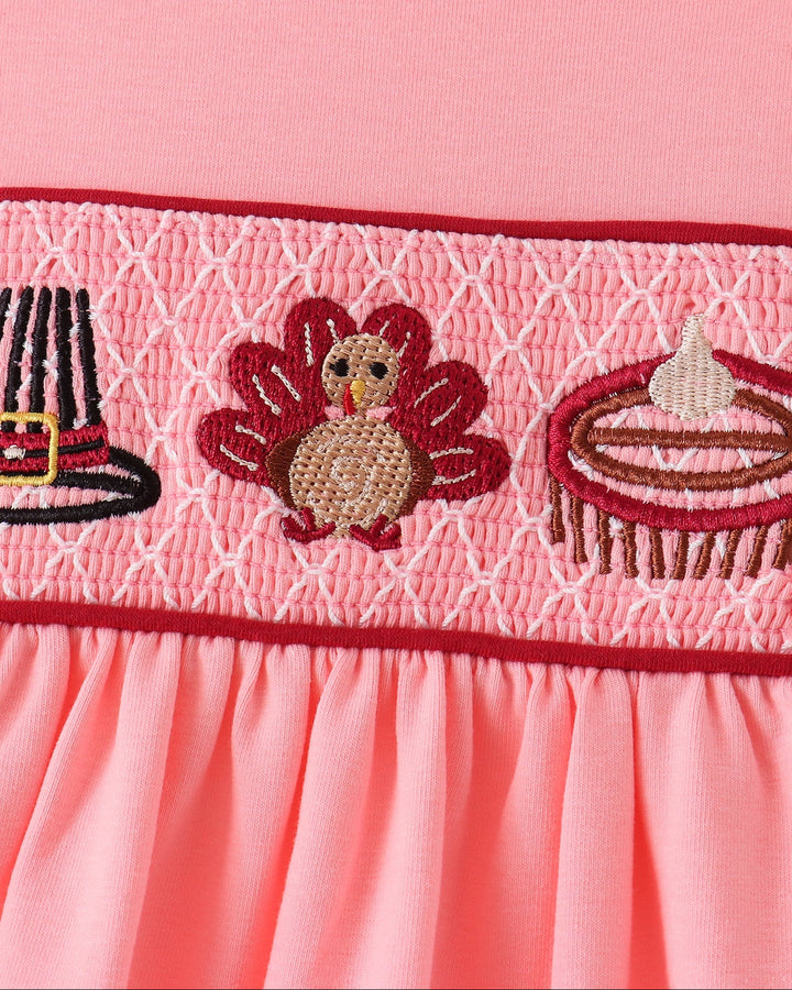 Pink smocked yoke with stitched turkey, hat, and striped food embroidery