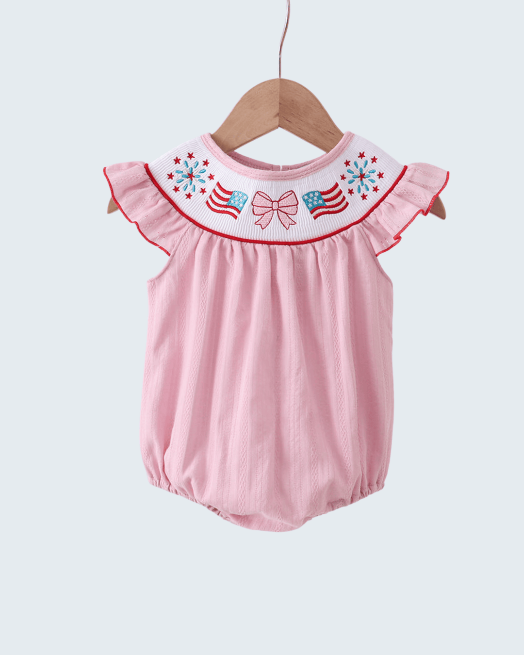 Pink baby romper with embroidered details on a white background