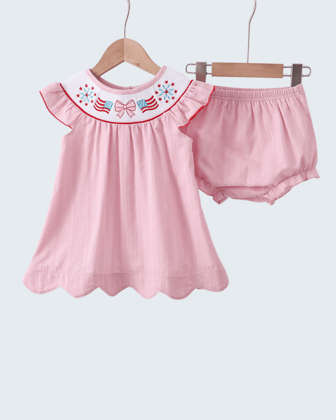 Pink baby outfit with ruffled collar and matching bloomers on a white background