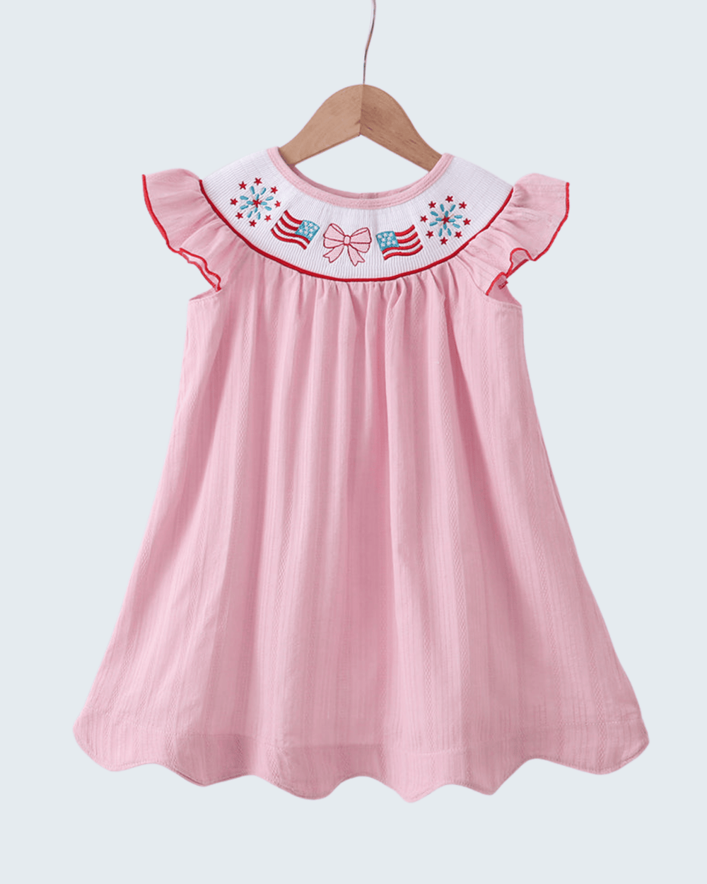 Pink dress with embroidered details on a white background