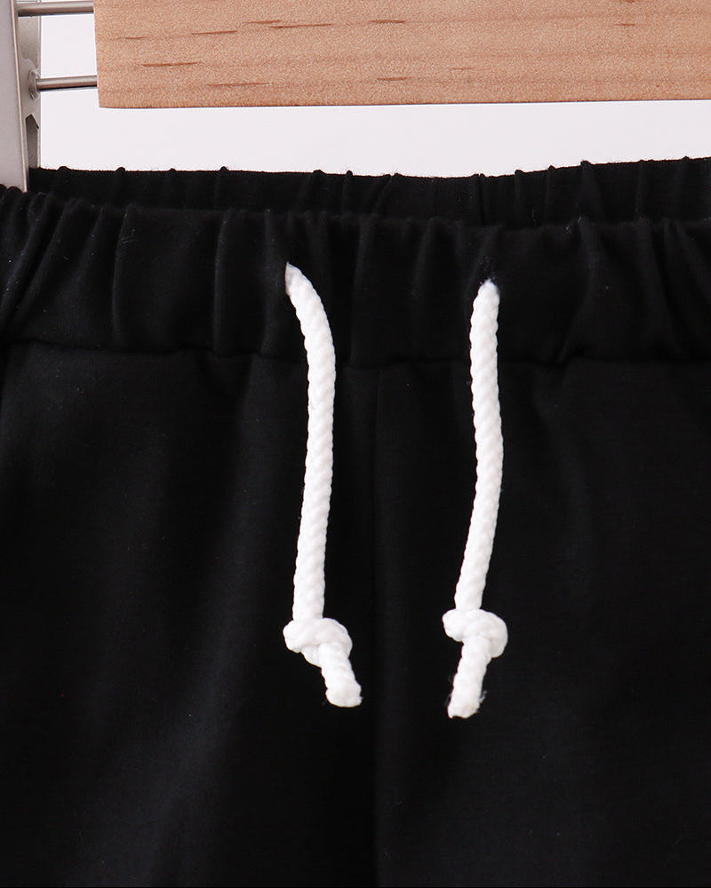 Black drawstring shorts with elastic waistband and white rope ties, close-up