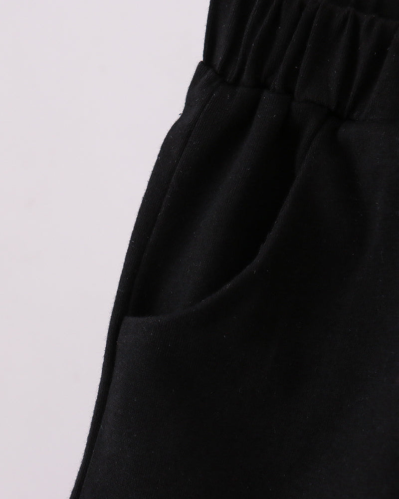 Black shorts with elastic waistband and draped fabric, side view