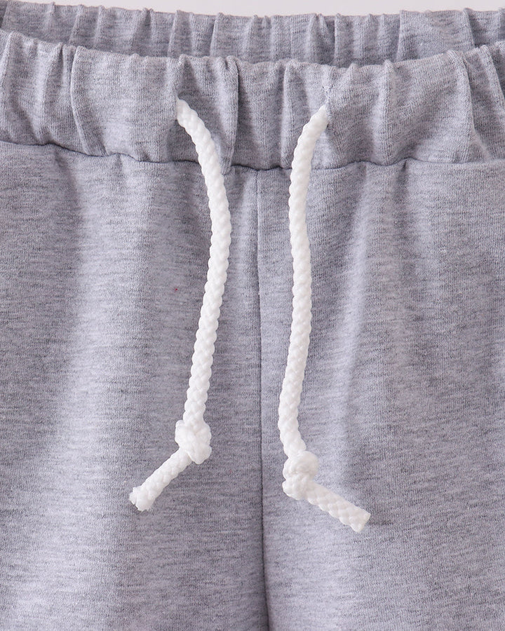 Grey drawstring shorts with elastic waistband and white rope ties