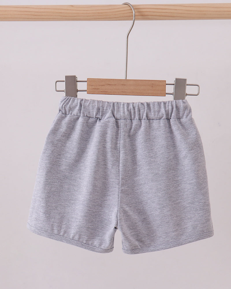 Grey drawstring shorts hanging with gathered elastic waistband