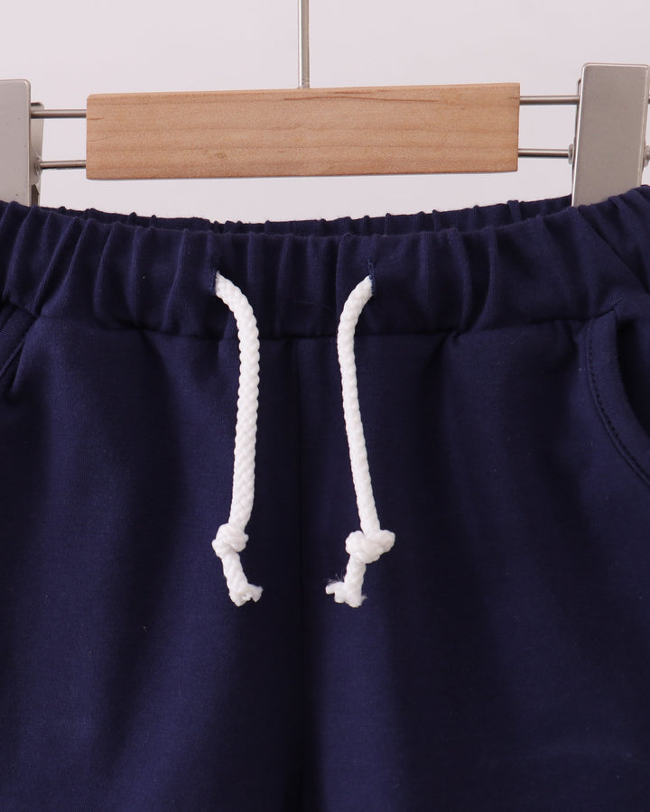 Navy drawstring shorts with elastic waistband and white rope ties