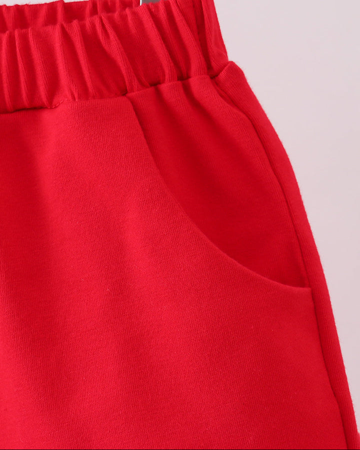 Red shorts with smooth front panel and curved pocket opening, side view