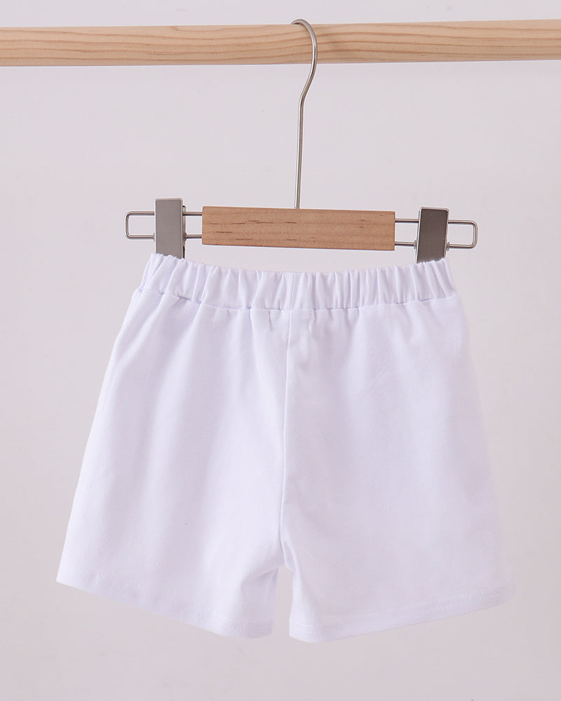 White elastic-waist shorts hanging on a wooden hanger