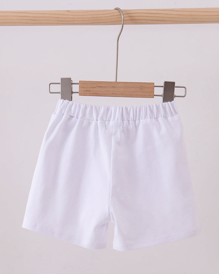 White elastic-waist shorts hanging on a wooden hanger