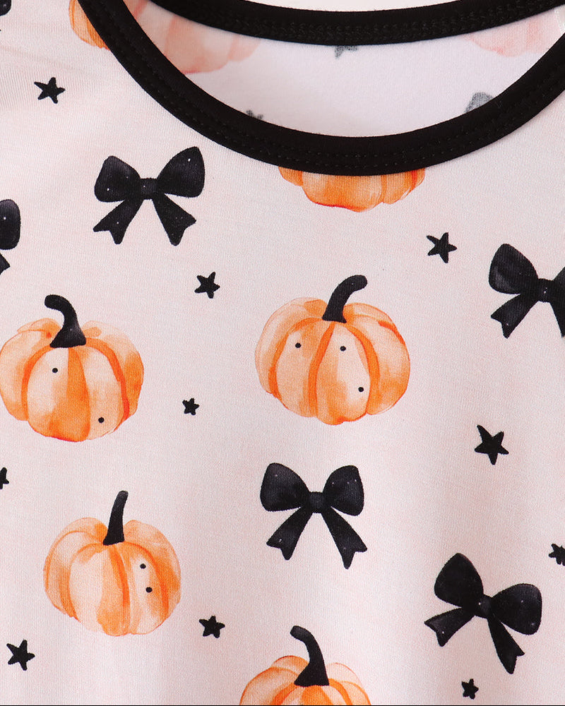 White bamboo pajama top neckline with black trim, pumpkin and bow pattern