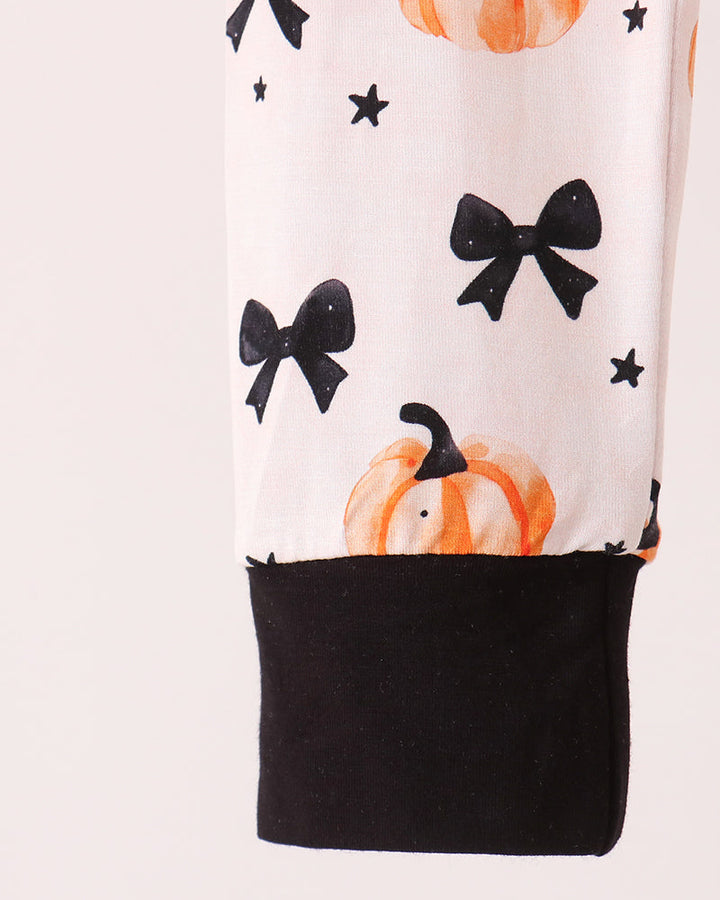 White bamboo pajama top with black hem panel, orange pumpkin and bow print