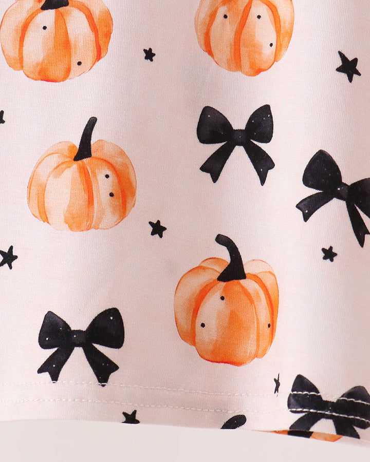 White bamboo pajama fabric with orange pumpkins, black bows, and small star accents