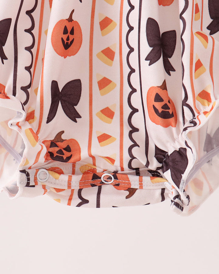 White romper with orange pumpkin and black bow print, gathered waist and ruffled leg hem