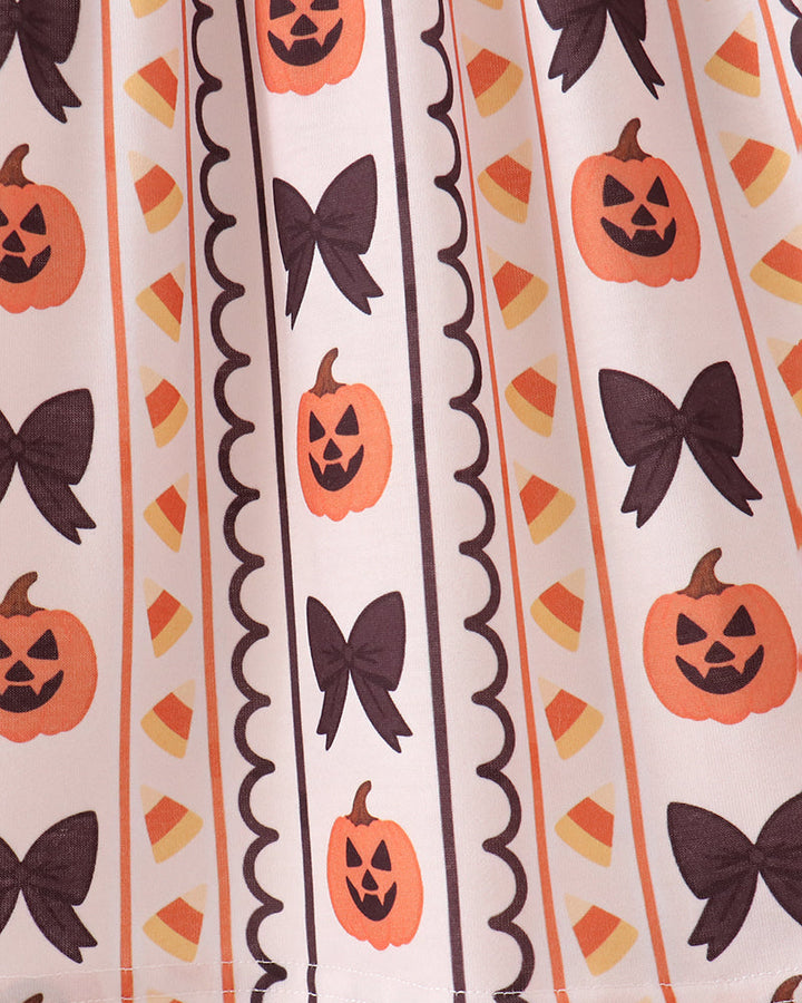 Pumpkin and bow print ruffle dress panel with vertical black trim and scalloped edge