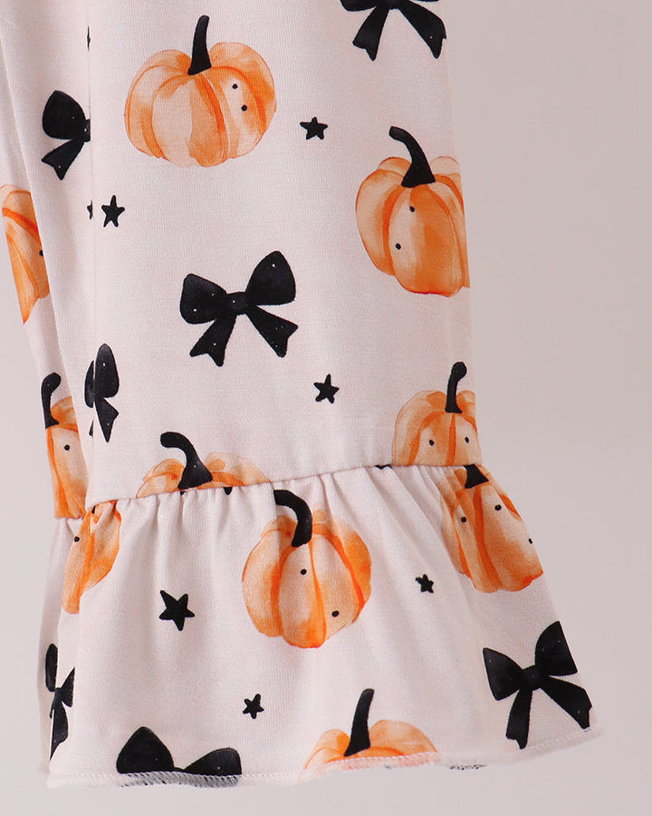 Kids pajama top and shorts set with orange pumpkins, black bows, and ruffled hem.