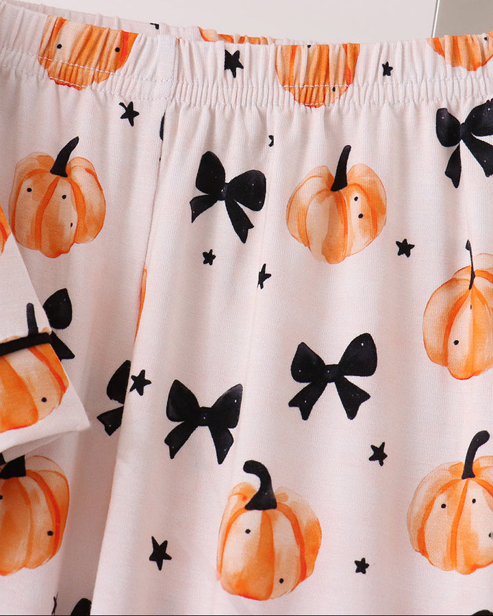 Kids pajama pants with elastic waist and full orange pumpkin-and-bow print.