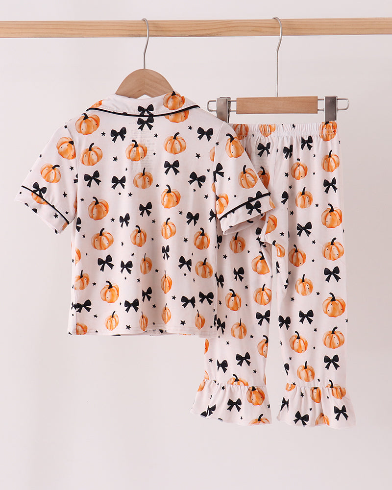 Kids pajama set with button-up shirt and matching pants, orange pumpkin and bow print.